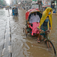 Rickshaw pullers make their way through a water-logged street after a heavy downpour in Dhaka on June 21, 2020.